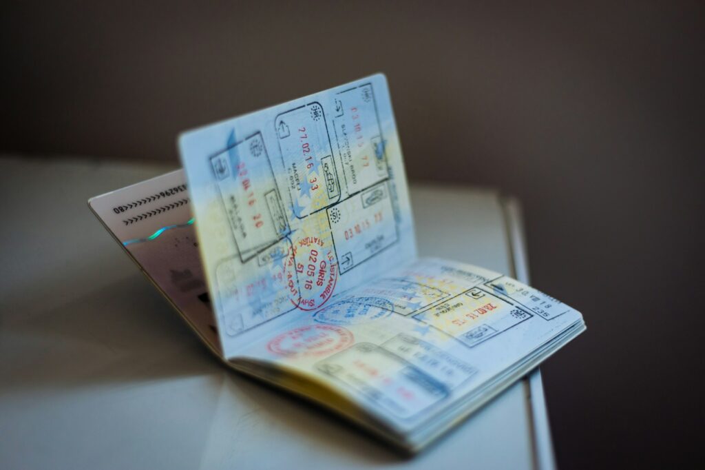 Aufgeschlagener Reisepass mit zahlreichen Visastempeln — Symbol für den langen Aufenthaltsweg vor der deutschen Einbürgerung