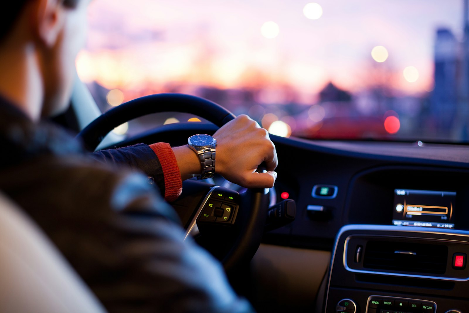 Fahrer mit Blick auf die Armbanduhr am Lenkrad in der Dämmerung — Sinnbild für die begrenzte Übergangsfrist beim Führerschein umschreiben in Deutschland